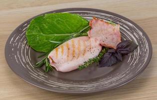 Grilled squid on the plate and wooden background photo