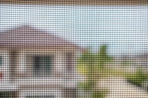 pantalla de alambre de mosquitera en la protección de la ventana de la casa contra insectos foto