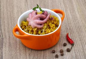 Seafood risotto in a bowl on wooden background photo