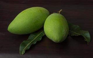 Green mango on wooden background photo