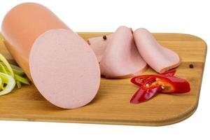 Sausages on wooden board and white background photo