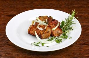 Shashlik on the plate and wooden background photo