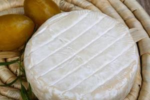 Brie cheese on wooden board and wooden background photo