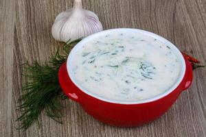 Tzatziki in a bowl on wooden background photo