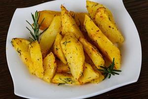 Roasted potato on the plate and wooden background photo