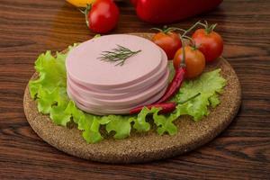 Sausage on wooden board and wooden background photo