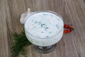 Tzatziki in a bowl on wooden background photo