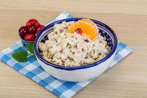 Oatmeal in a bowl on wooden background photo