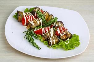 Eggplant roll on the plate and wooden background photo