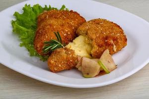 Fried cheese on the plate and wooden background photo