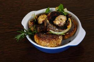 Baked champignons in a bowl on wooden background photo