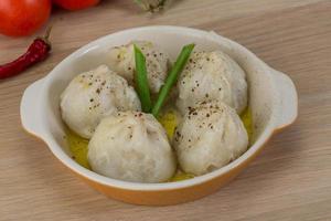 Khinkali in a bowl on wooden background photo