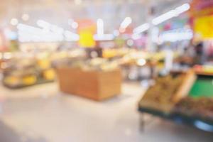 Supermarket with fresh fruits and vegetable on shelves in store blurred background photo