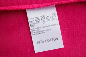 White laundry care washing instructions clothes label on red cotton shirt photo