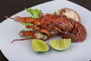 Spiny lobster on the plate and wooden background photo