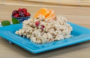 Oatmeal on the plate and wooden background photo