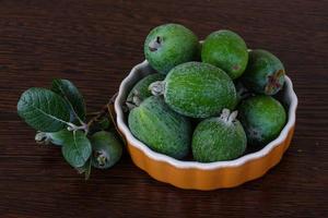 fruta feijoa en un bol sobre fondo de madera foto