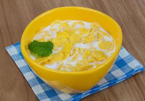 Cornflakes in a bowl on wooden background photo