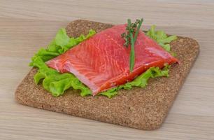 Salmon on wooden board and wooden background photo