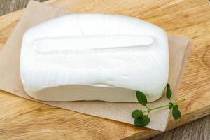 Feta cheese on wooden board and wooden background photo