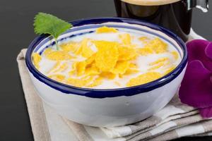 Cornflakes in a bowl on wooden background photo