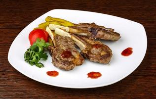 Lamb chops on the plate and wooden background photo