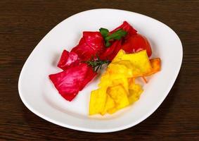 Pickled cabbage on the plate and wooden background photo