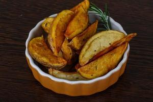 Roasted potato in a bowl on wooden background photo