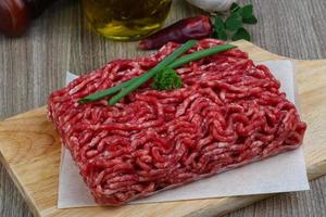 Minced beef on wooden board and wooden background photo