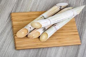 Sugar sticks on wooden board and wooden background photo