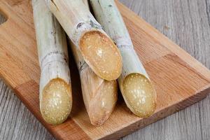 Sugar sticks on wooden board and wooden background photo