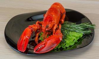 Boiled lobster on the plate and wooden background photo