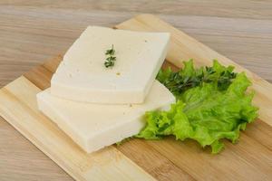 Yellow cheddar on wooden board and wooden background photo