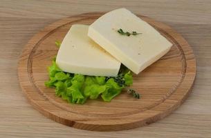 Yellow cheddar on wooden board and wooden background photo