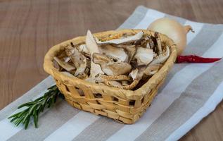 shiitake seco en una cesta sobre fondo de madera foto