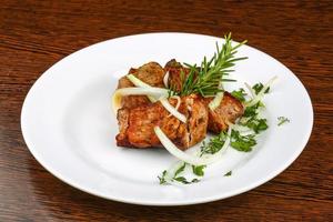 Shashlik on the plate and wooden background photo