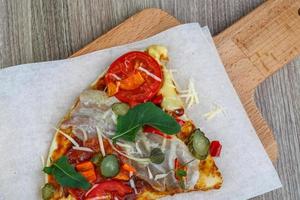 Pizza on wooden board and wooden background photo