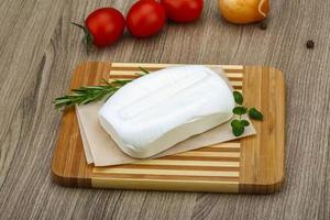 Feta cheese on wooden board and wooden background photo