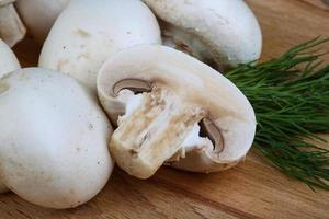 Champignons on wooden board and wooden background photo