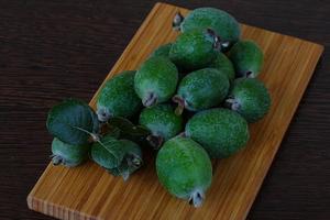 fruta feijoa sobre tablero de madera y fondo de madera foto