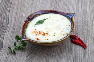 Cheese soup in a bowl on wooden background photo