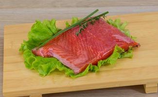 Salmon on wooden board and wooden background photo