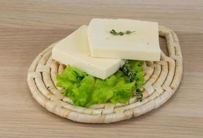 Yellow cheddar on wooden board and wooden background photo