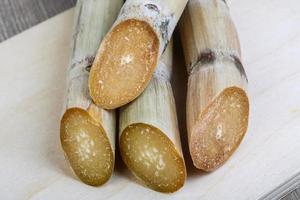 palitos de azúcar en tablero de madera y fondo de madera foto