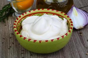 Mayonnaise sauce in a bowl on wooden background photo