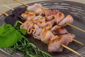 Grilled squid on the plate and wooden background photo