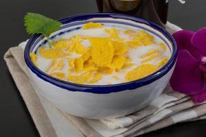 Cornflakes in a bowl on wooden background photo