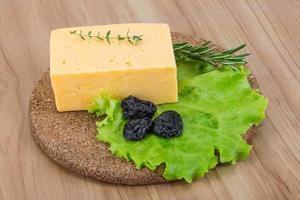 Yellow cheese on wooden board and wooden background photo