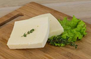 Yellow cheddar on wooden board and wooden background photo