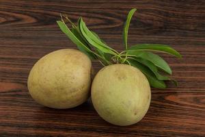 Sapodilla on wooden background photo